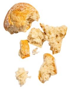 Partially eaten bread ripped with large and small crumbs.
