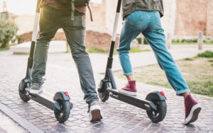 Two people riding on electric scooters