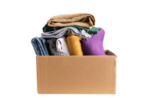 Cardboard box with folded used clothing inside and on top